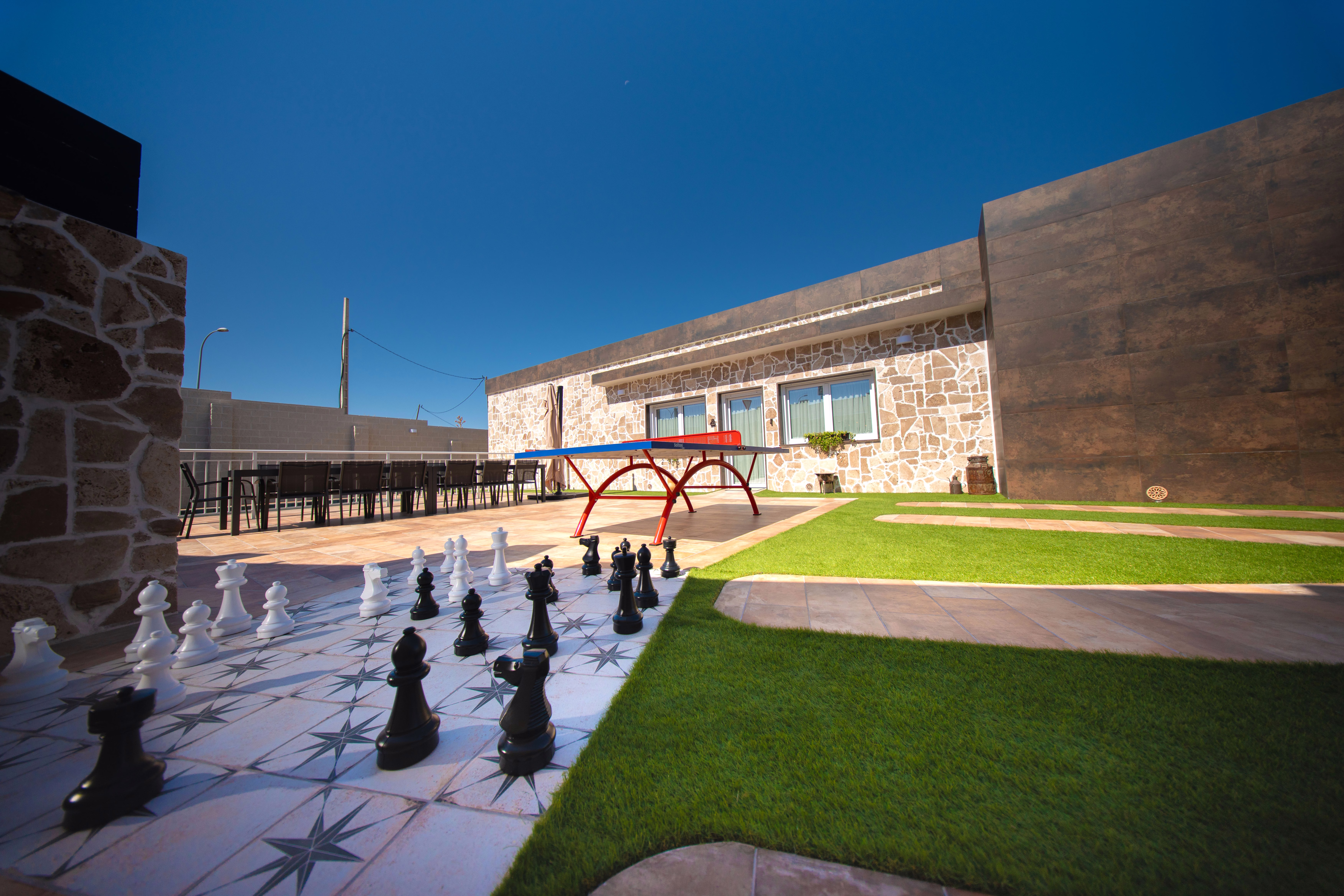 Ajedrez gigante de exterior y mesa de ping pong en el jardín